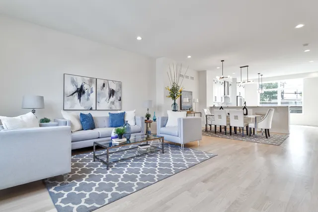 a living room with furniture and a dining table with wooden floor