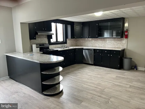 a kitchen with stainless steel appliances granite countertop a sink a stove and a microwave