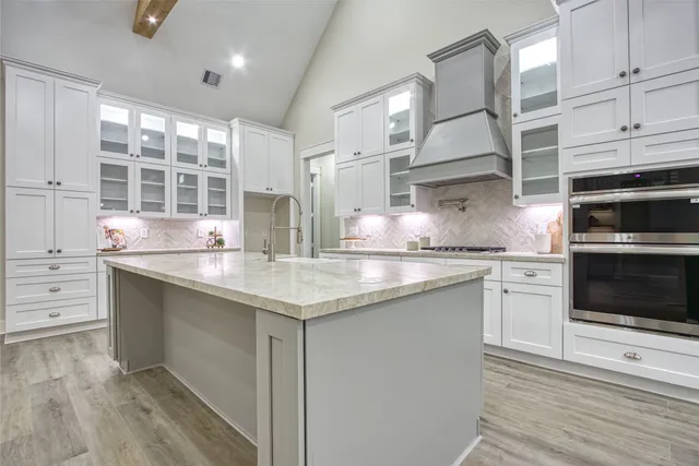 a view of a kitchen with stainless steel appliances wooden floor and a large window