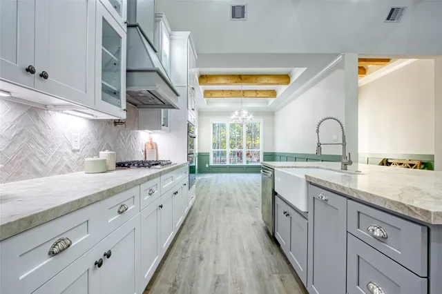 a kitchen with granite countertop a sink stainless steel appliances and cabinets