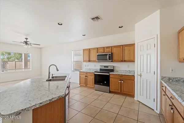 a kitchen with a sink a stove top oven and cabinets