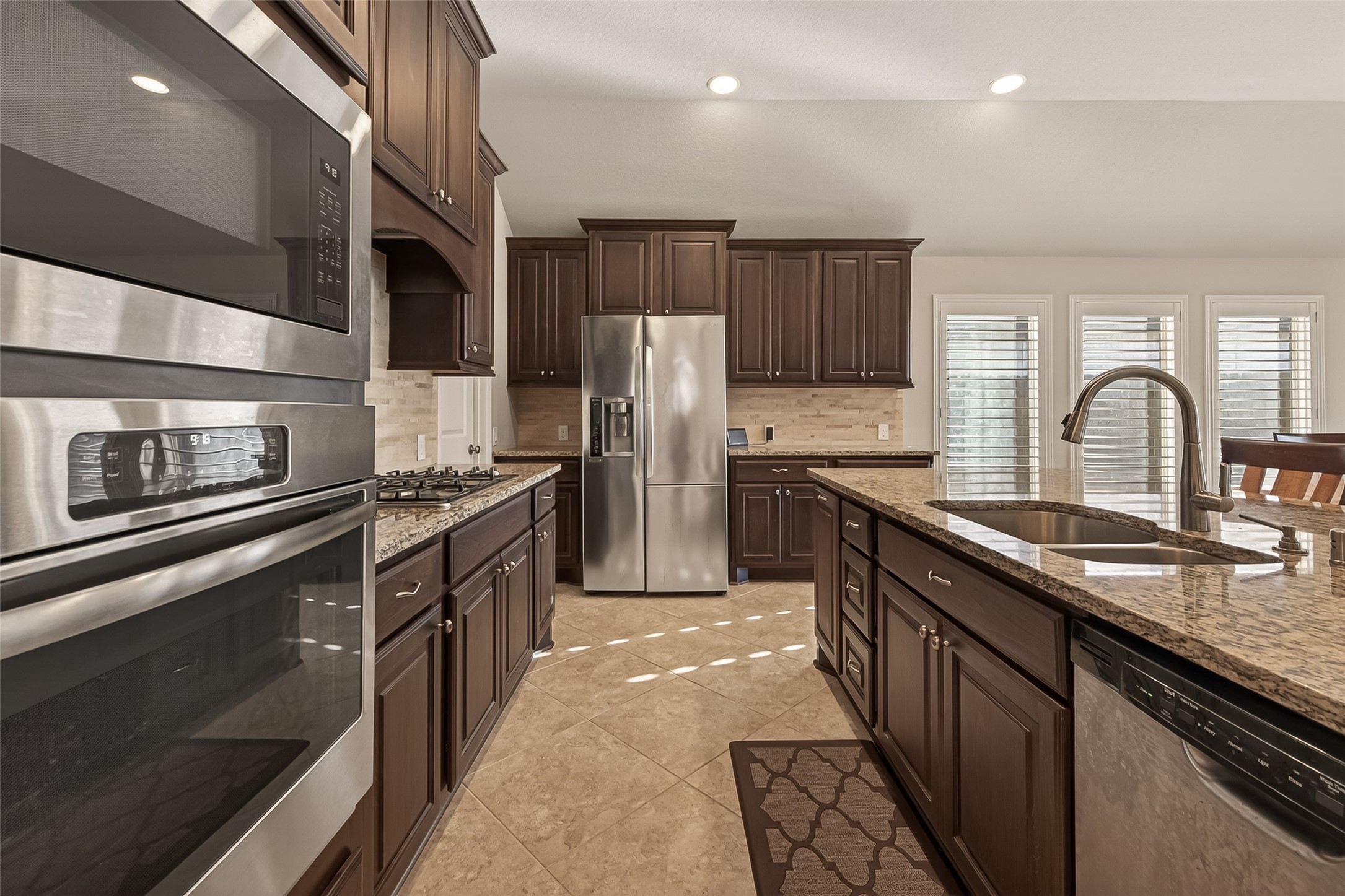 28435 Sycamore Falls Lane Fulshear, TX 77441 - Photo 15 of 46 a kitchen with stainless steel appliances granite countertop a sink stove and refrigerator
