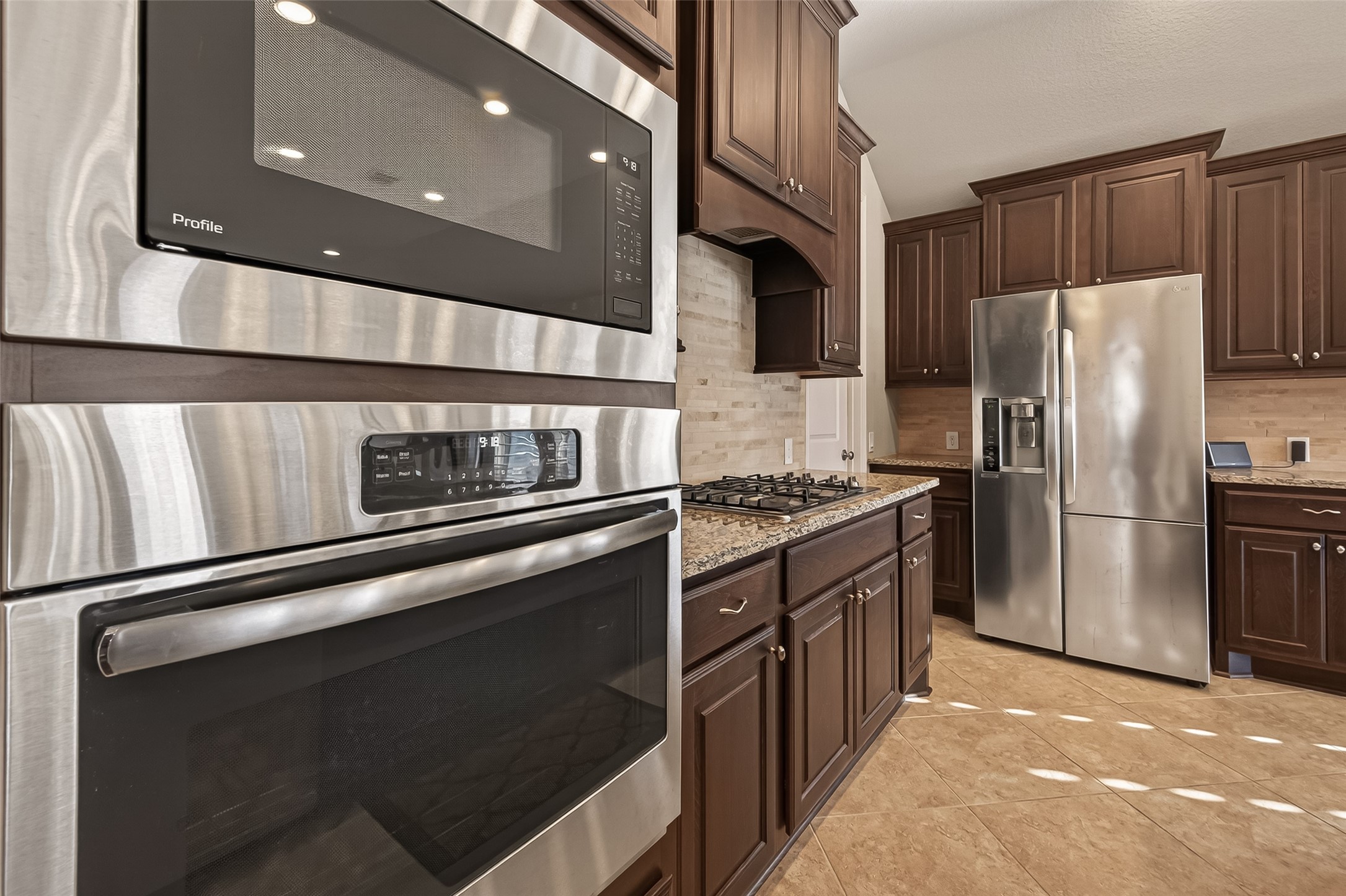 28435 Sycamore Falls Lane Fulshear, TX 77441 - Photo 17 of 46 a kitchen with granite countertop stainless steel appliances and wooden cabinets