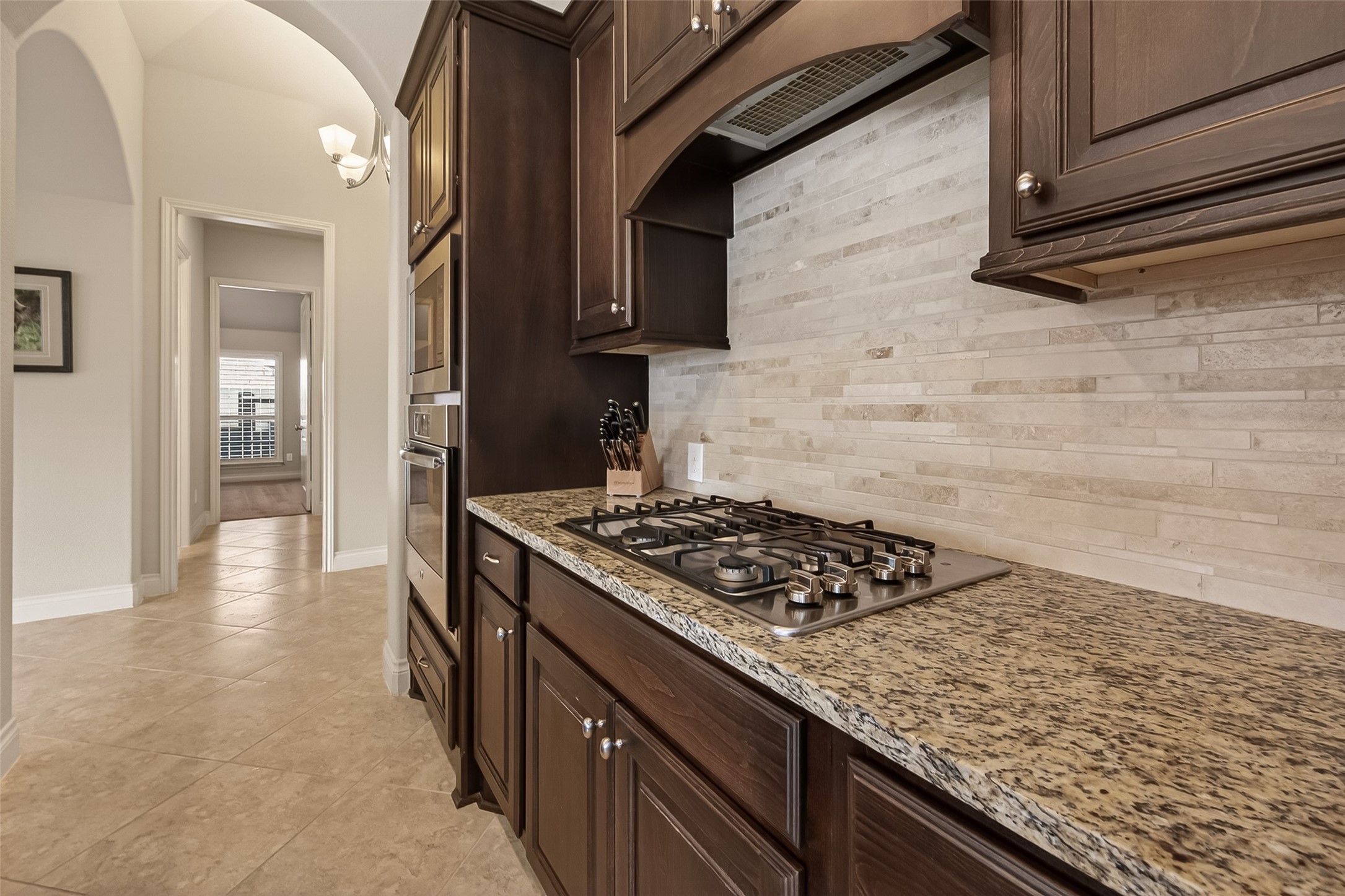 28435 Sycamore Falls Lane Fulshear, TX 77441 - Photo 21 of 46 a kitchen with stainless steel appliances granite countertop a stove and a wooden cabinets