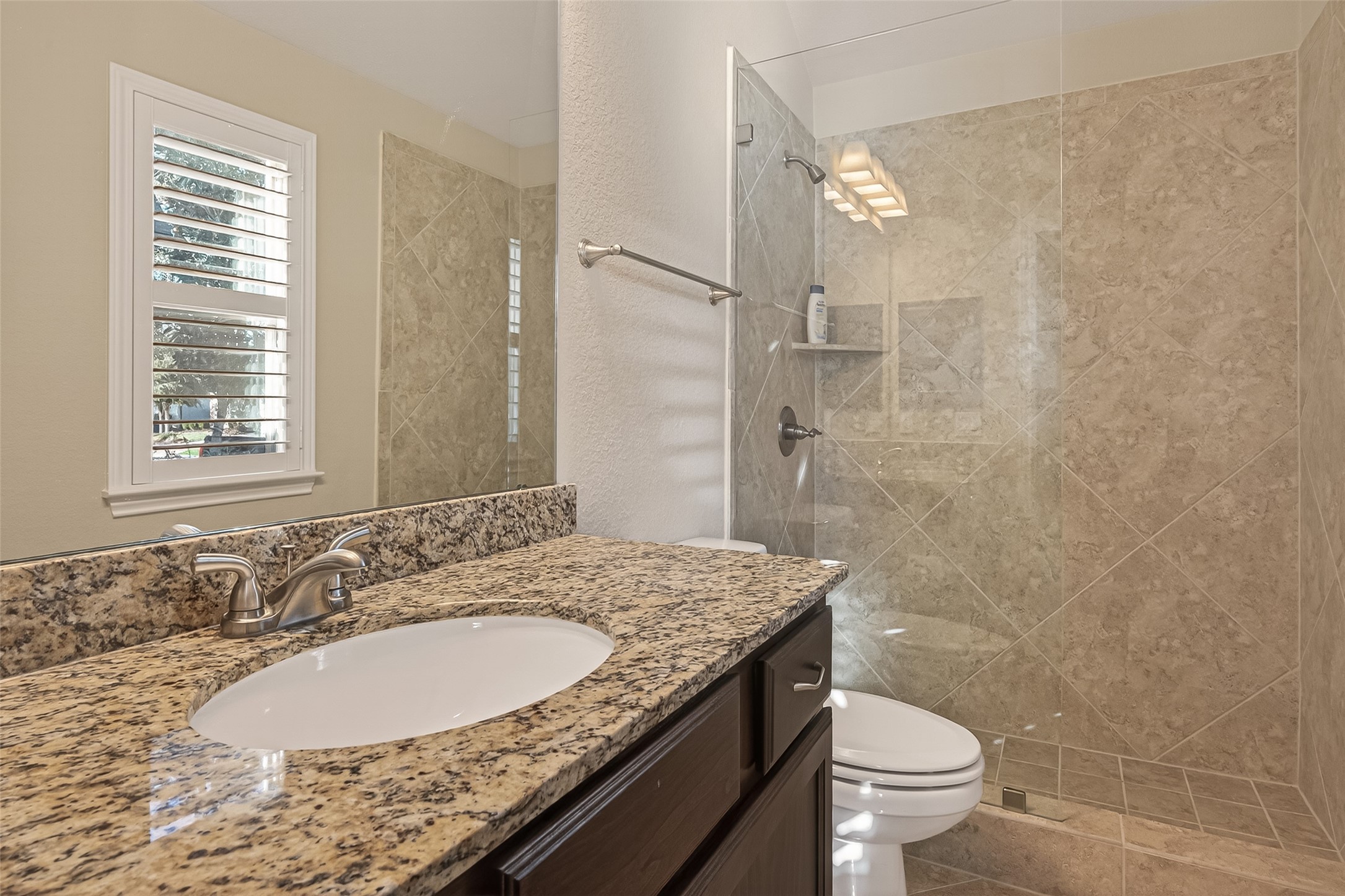 28435 Sycamore Falls Lane Fulshear, TX 77441 - Photo 30 of 46 a bathroom with a granite countertop sink toilet and shower