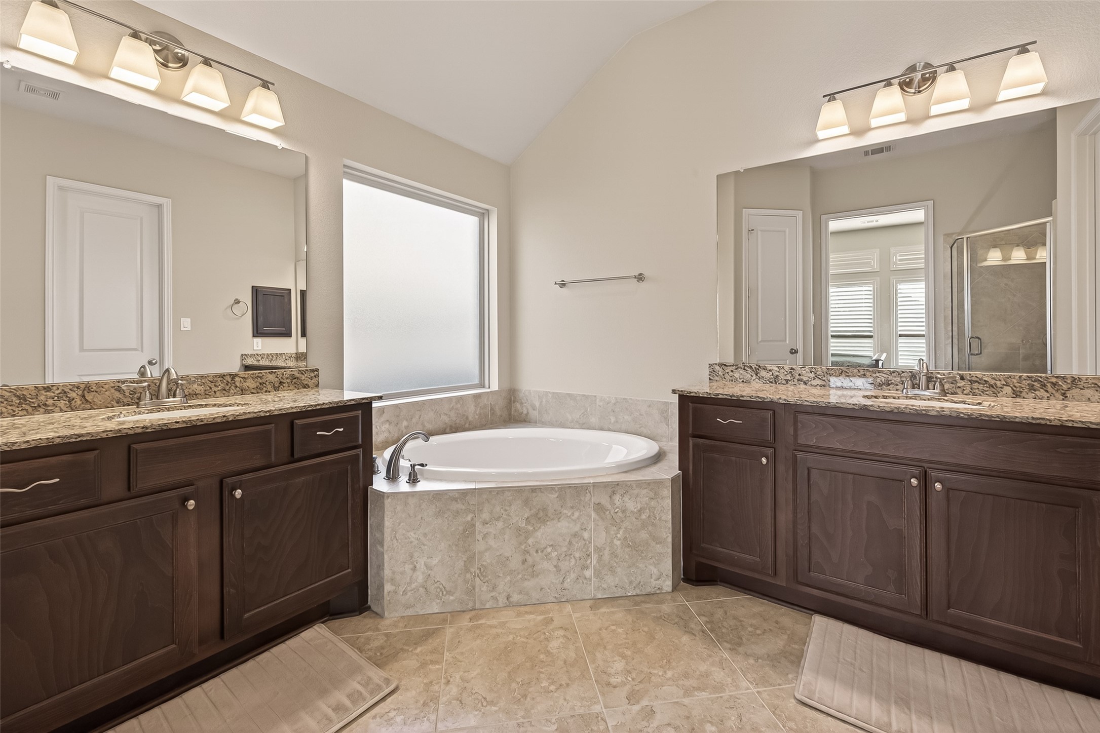 28435 Sycamore Falls Lane Fulshear, TX 77441 - Photo 40 of 46 a bathroom with a granite countertop double vanity sink and mirror with bathtub