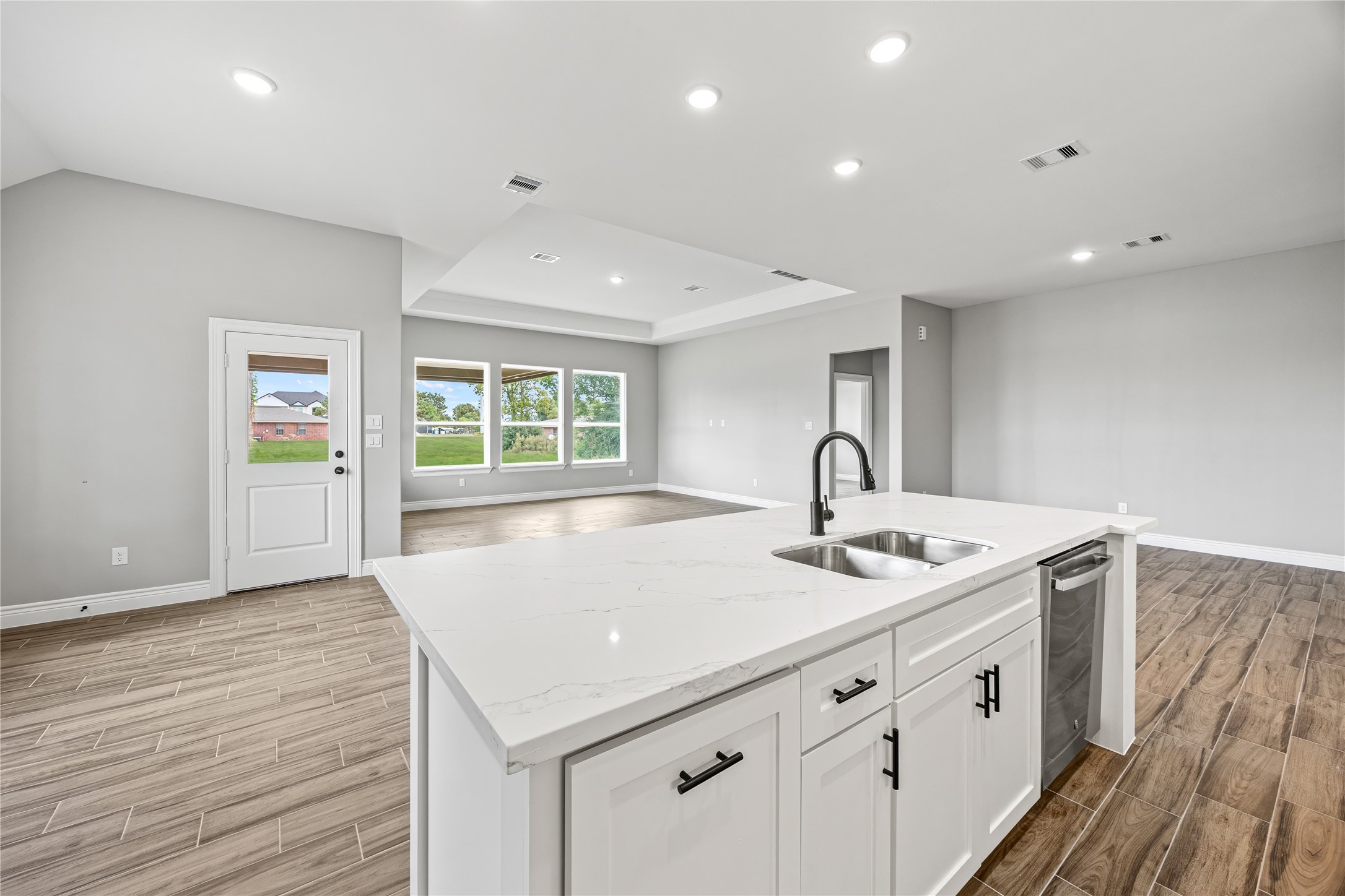 513 Oleander Street Waller, TX 77484 - Photo 11 of 28 a view of center kitchen with stainless steel appliances granite countertop white cabinets and window