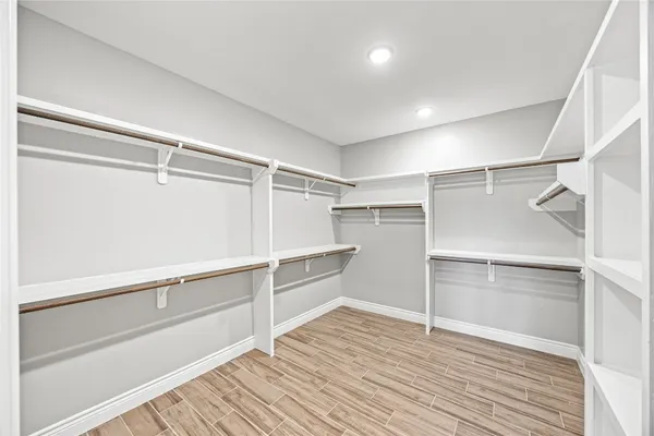 a view of walk in closet with empty racks
