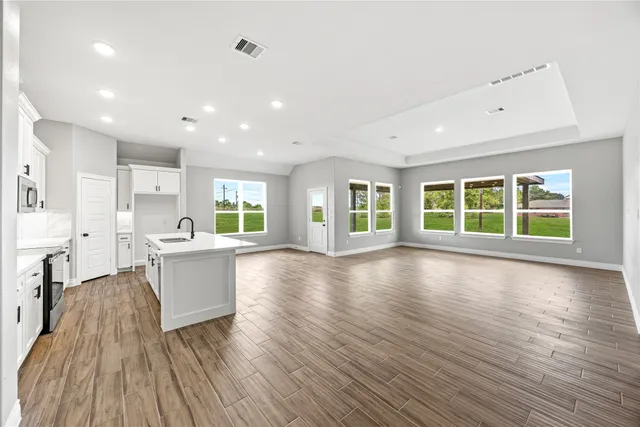 a view of a kitchen with wooden floor and a window