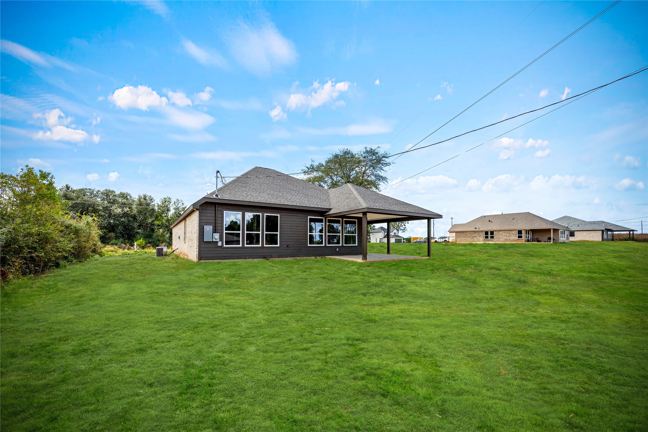 513 Oleander Street Waller, TX 77484 - Photo 27 of 28 a view of a big house with a big yard and large trees