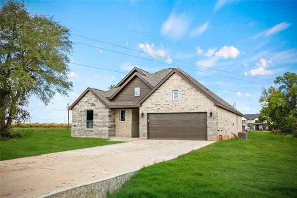 a front view of a house with a garden and yard