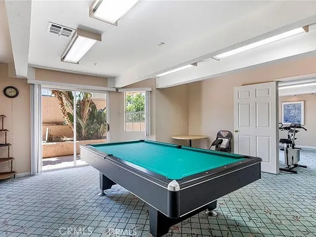 a room with pool table and windows