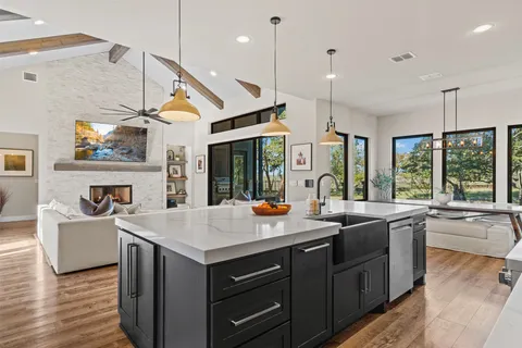 a kitchen with a sink stove and wooden floor