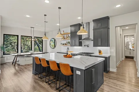 a kitchen with a sink a counter and chairs