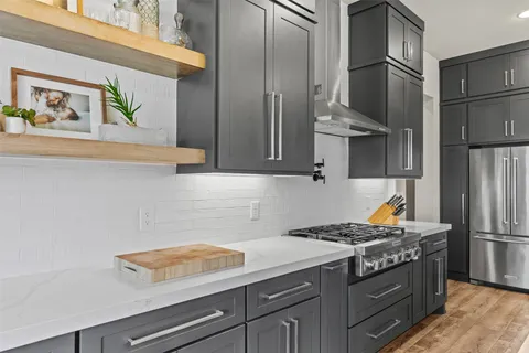 a kitchen with stainless steel appliances granite countertop a refrigerator and a stove