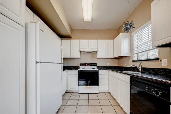 a kitchen with granite countertop white cabinets and white appliances