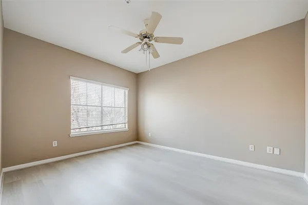 an empty room with a ceiling fan and a fan