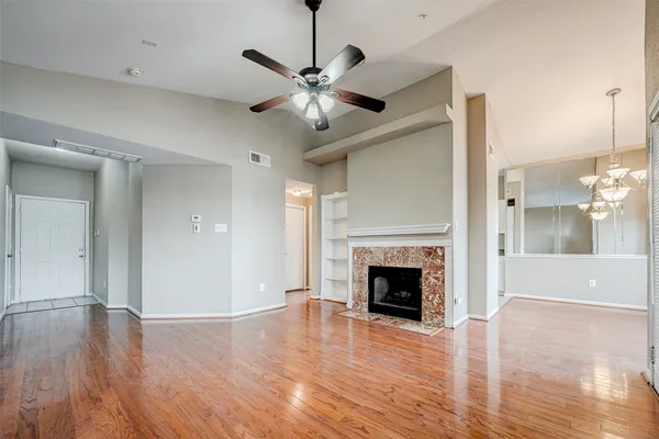 a view of a livingroom with a chandelier fan and windows