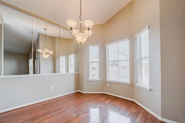 a kitchen with stainless steel appliances granite countertop a refrigerator a sink dishwasher a stove and white cabinets with wooden floor