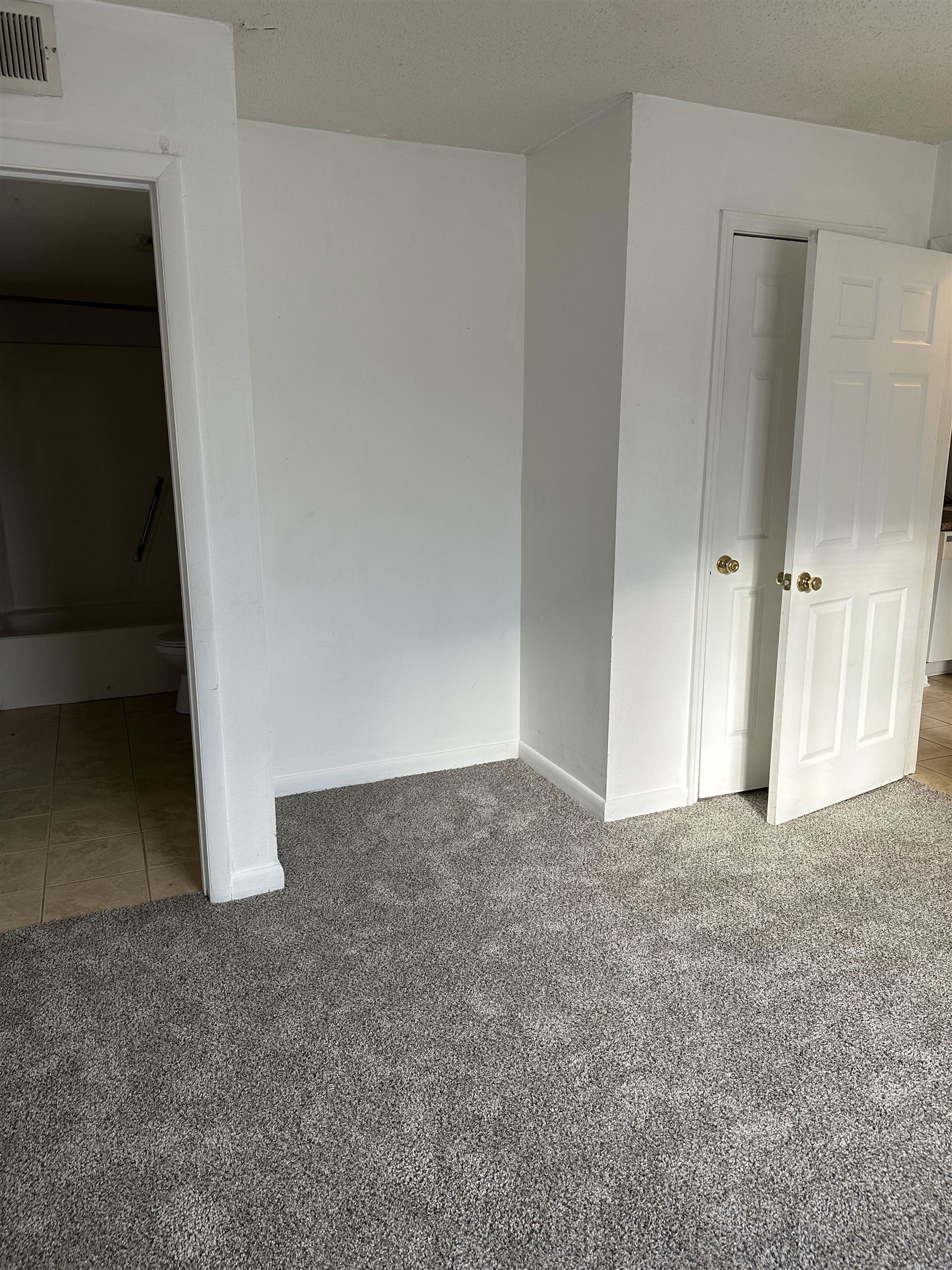 3555 Highway 544, Unit 18G Conway, SC 29526 - Photo 7 of 11 Unfurnished bedroom with light carpet, a textured ceiling, and ensuite bath