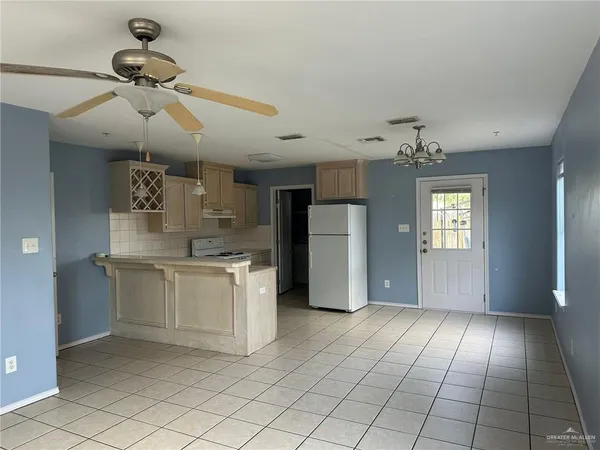 a kitchen with stainless steel appliances kitchen island granite countertop a refrigerator a stove and a sink