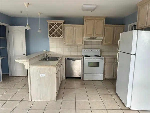 a kitchen with a stove a refrigerator and a sink