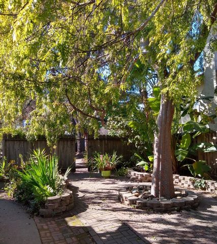 a front view of a house with a yard and tree s