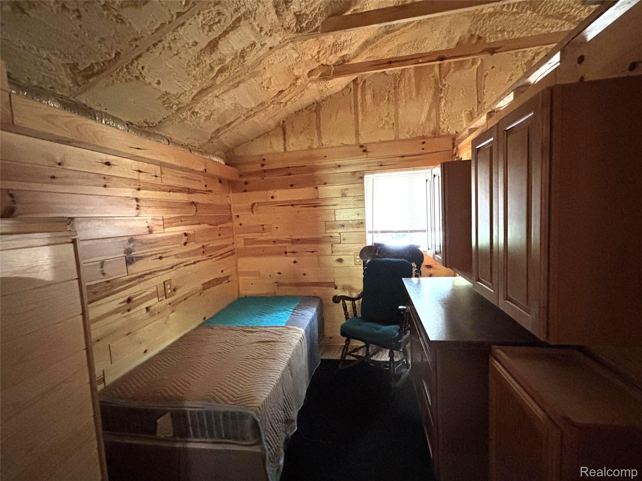955 Aeronca Road Luzerne, MI 48636 - Photo 12 of 20 Interior room featuring wood plank wall finishes, exposed beam vaulted ceiling with spray foam insulation, and built-in cabinetry with a countertop