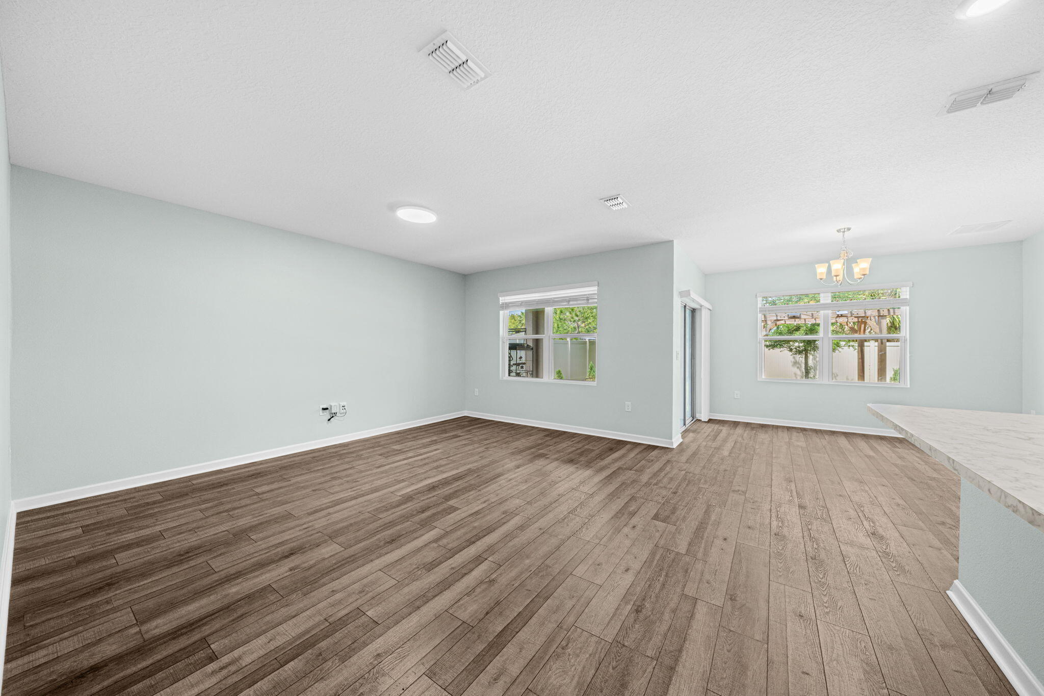 820 Forest Trace Circle Titusville, FL 32780 - Photo 9 of 27 an empty room with wooden floor and windows