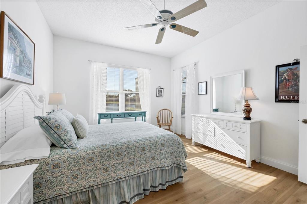 4115 Hemingway Drive Venice, FL 34293 - Photo 18 of 41 a bedroom with a large bed a chandelier and windows