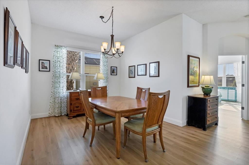 4115 Hemingway Drive Venice, FL 34293 - Photo 8 of 41 a view of a dining room with furniture wooden floor and chandelier