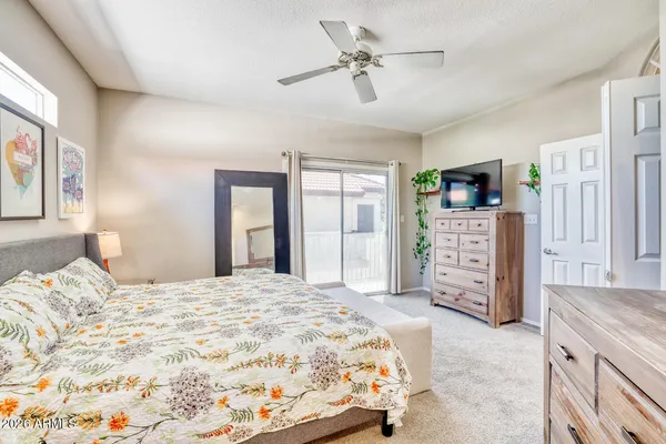 a bedroom with a large bed and a flat tv screen