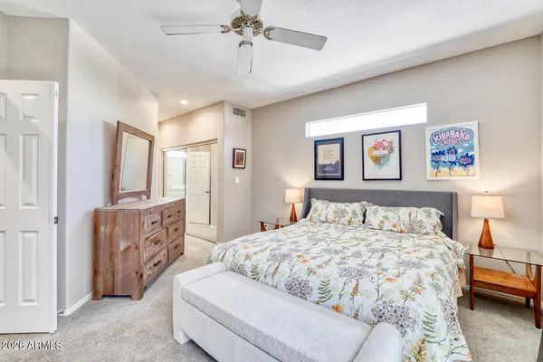a bedroom with a large bed and a chandelier