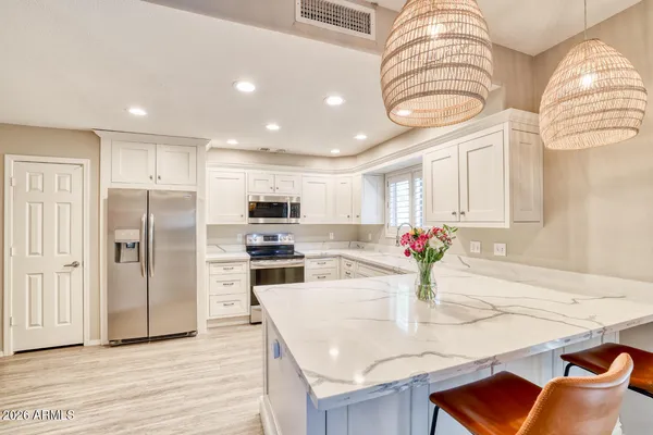 a kitchen with stainless steel appliances kitchen island granite countertop a refrigerator and microwave