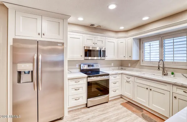 a kitchen with white cabinets and stainless steel appliances