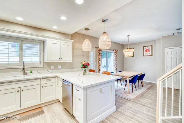 a view of a kitchen counter top space with sink stainless steel appliances and living room view