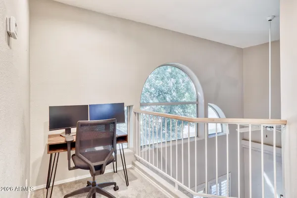 a view of a workspace with furniture and a window