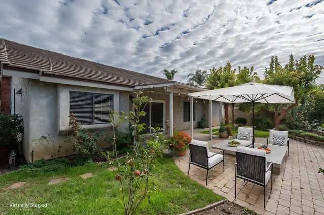 a patio with a table and chairs under an umbrella