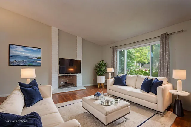 a living room with furniture a flat screen tv and a large window