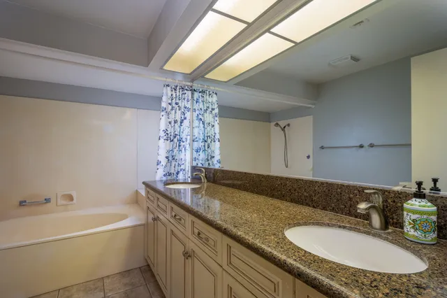 a bathroom with a granite countertop sink and a mirror