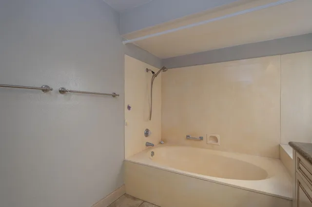a white bath tub sitting next to a white sink and vanity