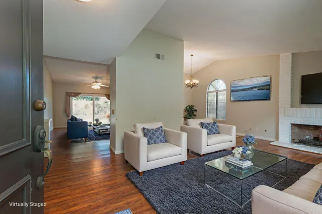 a living room with fireplace furniture and a wooden floor