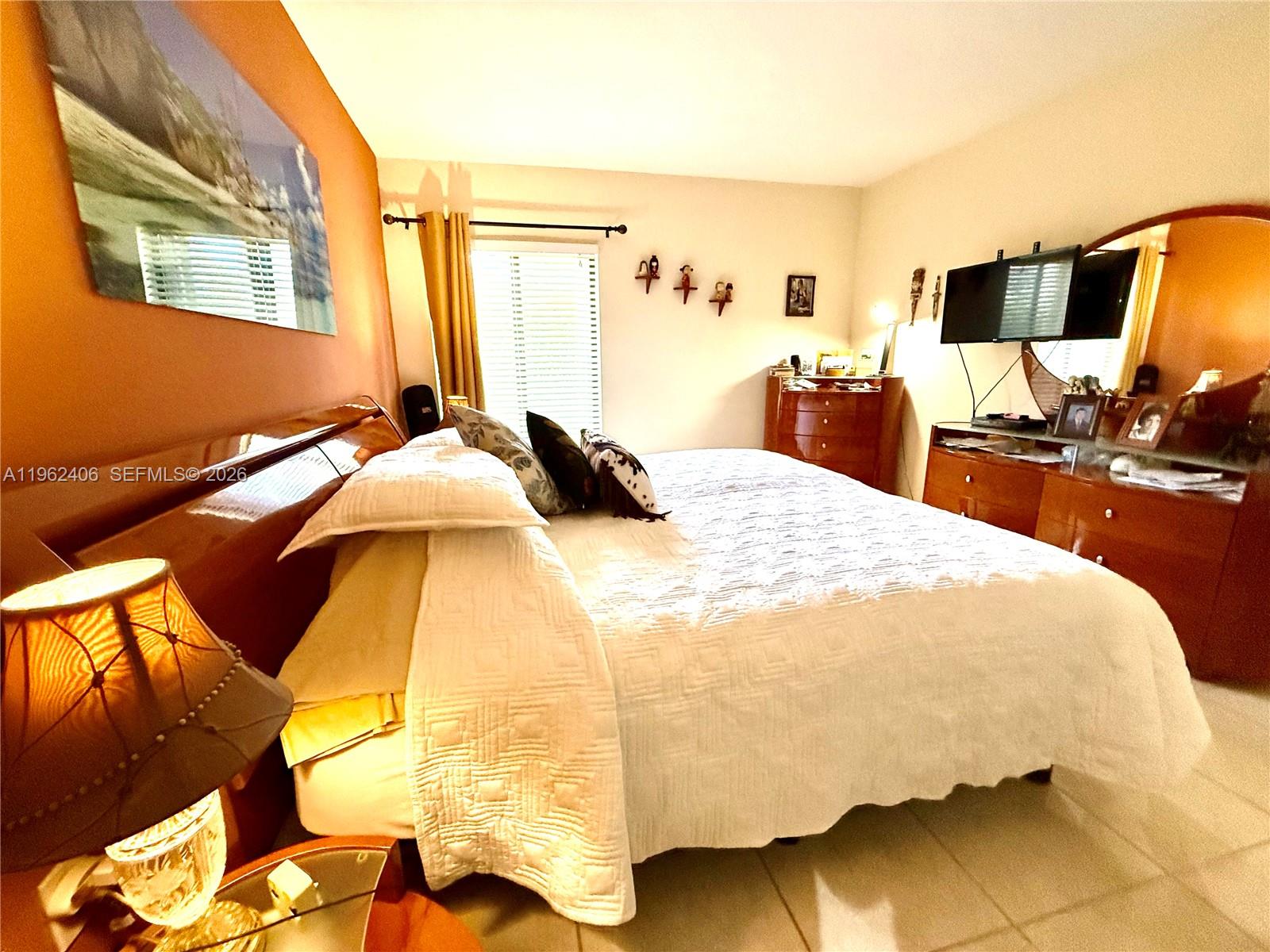 351 Club Circle, Unit 102 Boca Raton, FL 33487 - Photo 19 of 34 a bedroom with a bed and wooden floor