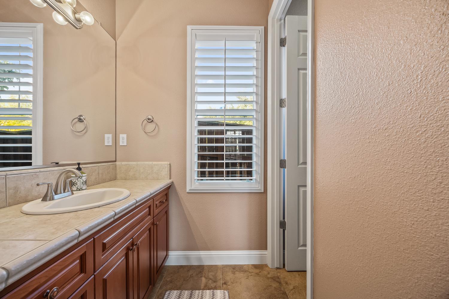 4183 North Bodega Bay Road Clovis, CA 93619 - Photo 20 of 30 a bathroom with a granite countertop sink and a mirror