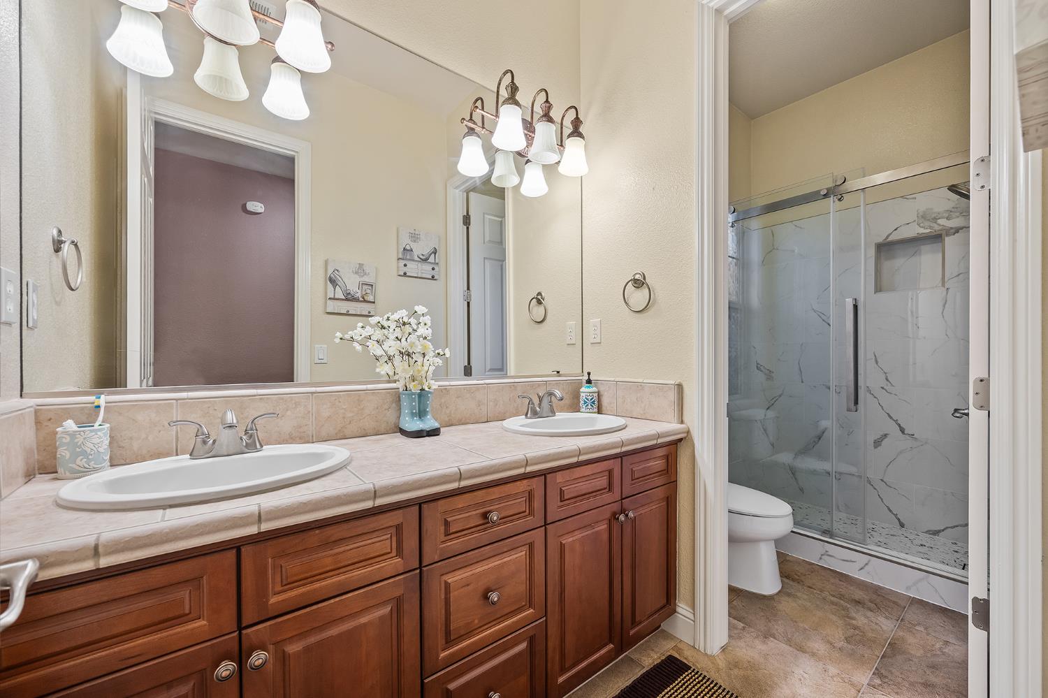 4183 North Bodega Bay Road Clovis, CA 93619 - Photo 23 of 30 a spacious bathroom with a granite countertop sink toilet mirror and shower