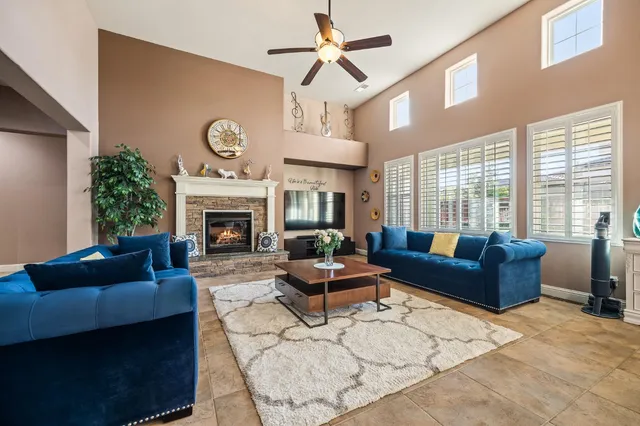 a living room with furniture a ceiling fan and a window