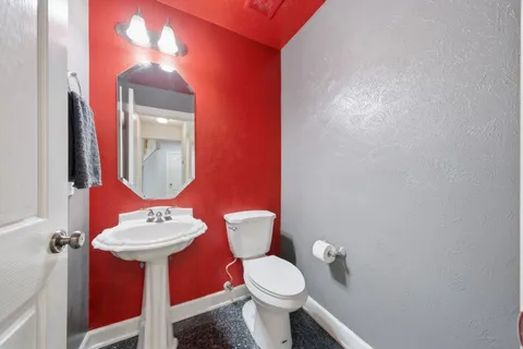 a bathroom with a toilet sink and mirror