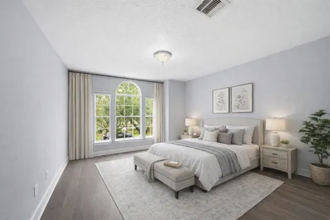 a bedroom with a bed and a large window