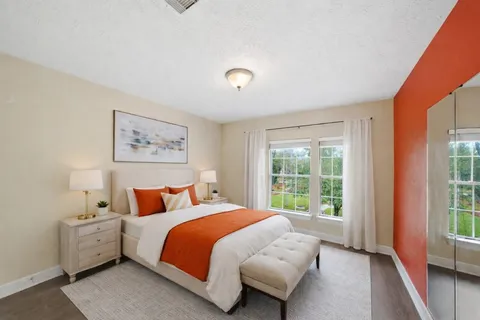 a bedroom with a bed and a large window