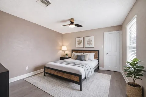 a bedroom with a bed and a potted plant